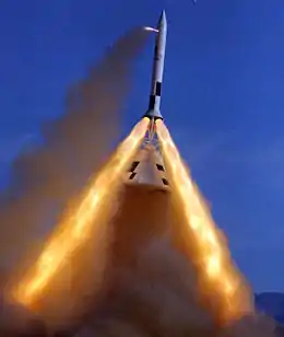 Pad Abort Test number 2.  A capsule is suspended underneath a rocket section with three exhaust plumes