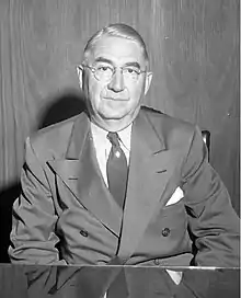 Black and white photo of Fischer sitting in a suit and tie