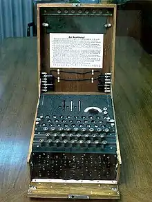 Enigma machine typewriter keypad over many rotors in a wood box