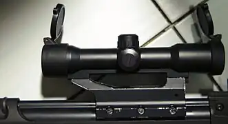 "STANAG" claw mount (receiver interface) on an FN FAL. This type of mount has also been used on several previous models by Heckler & Koch, such as for example MP5 and G3.