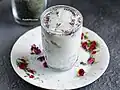 A picture of Iranian homemade Doogh drink (also known as Ayran) poured in a glass and decorated with dried rose and mint