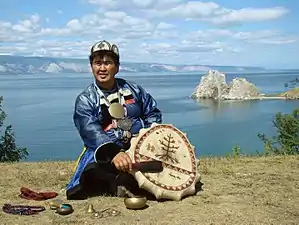 A shaman in front of Shaman Rock, a Buryat. Olkhon Island