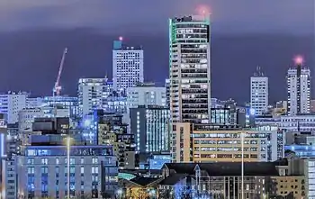 A cluster of modernist office buildings in at night.