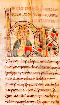  Illuminated manuscript with a forward facing man in the middle of the large H. Man is carrying a crozier and his head is surrounded by a halo