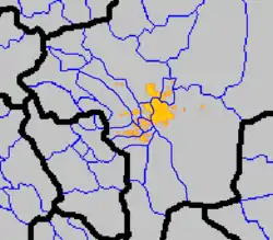 Map of the metropolitan area with provincial borders in black, county borders in blue, and cities with orange borders and yellow background