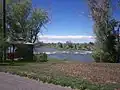 A gazebo on the greenbelt in Shelley, ID overlooks the Snake River as it flows over some rocks.  This gazebo was destroyed in 2009.