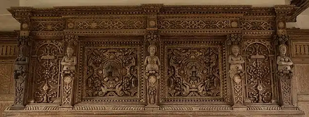 and a carved fireplace with male and female figures, interspersed with grotesque heads.