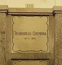 A marble gravestone on the wall of a crypt