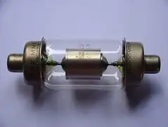 A glass cylinder capped on both ends with metal electrodes. Inside the glass bulb there is a metal cylinder connected to the electrodes.