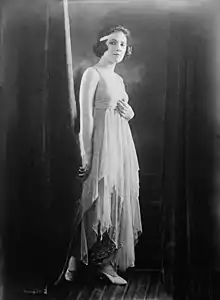 A young white woman standing in a sequined gown